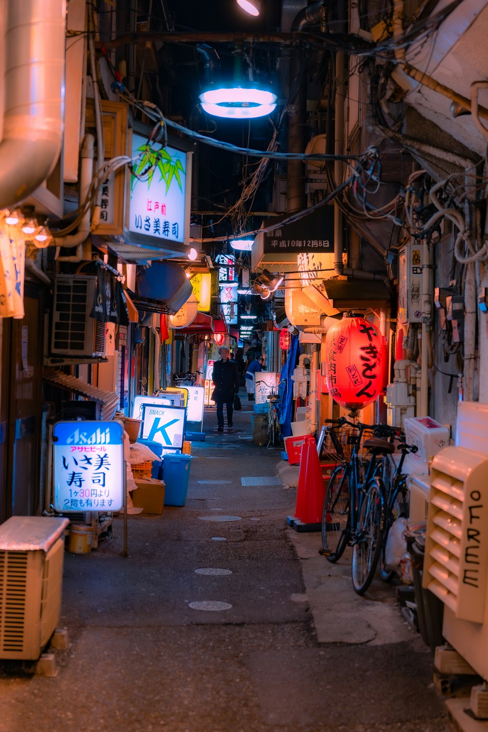 a narrow alley way with lots of signs and lights