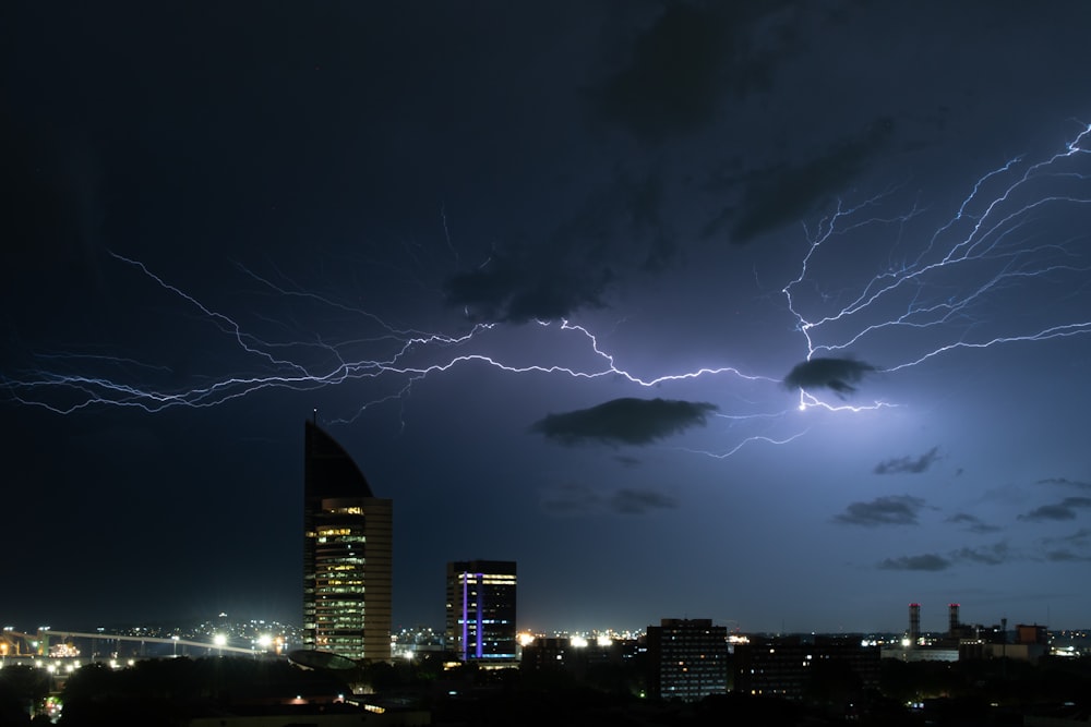 a lightning bolt strikes over a city at night