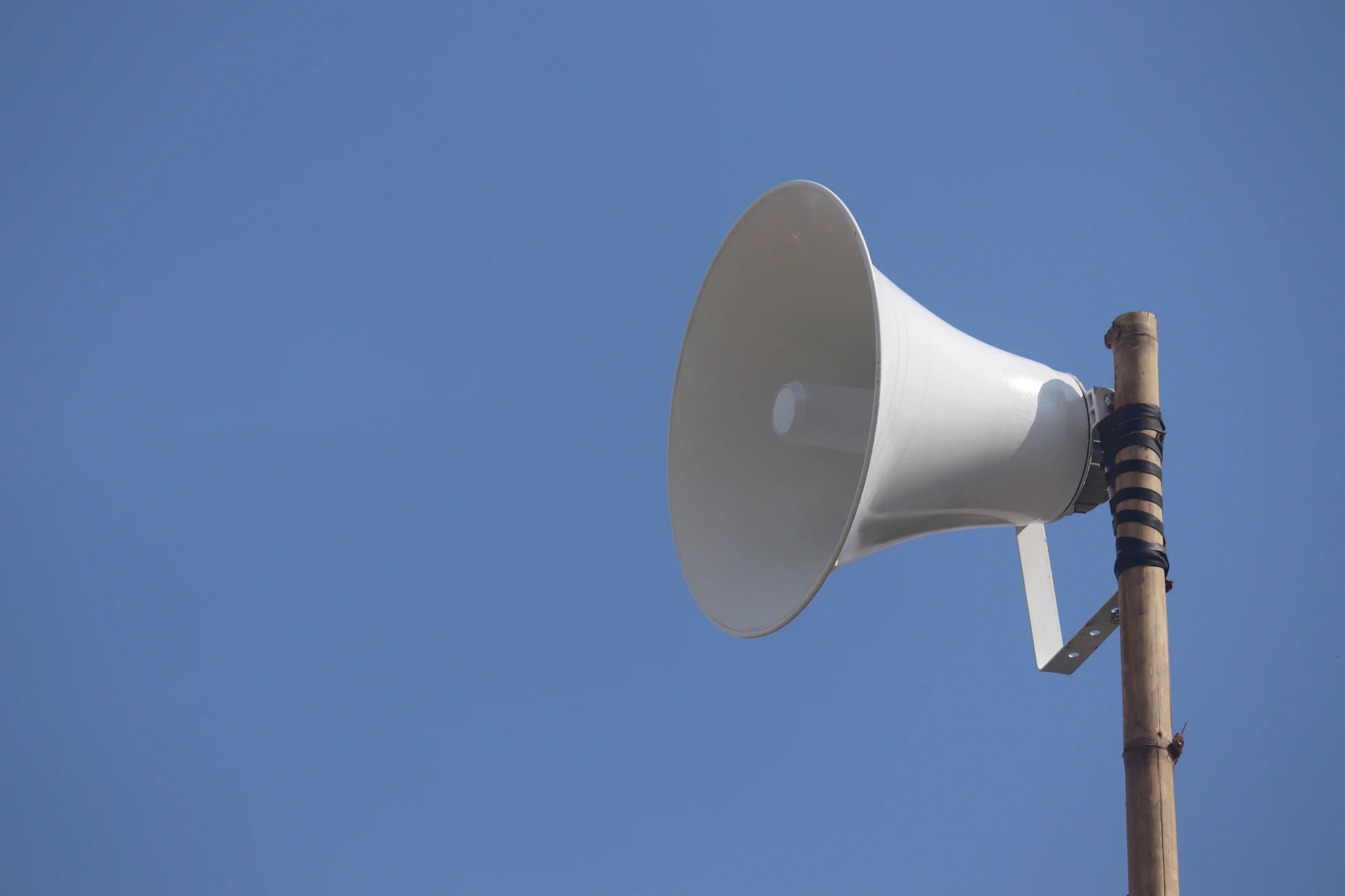 a white bullhorn on top of a wooden pole