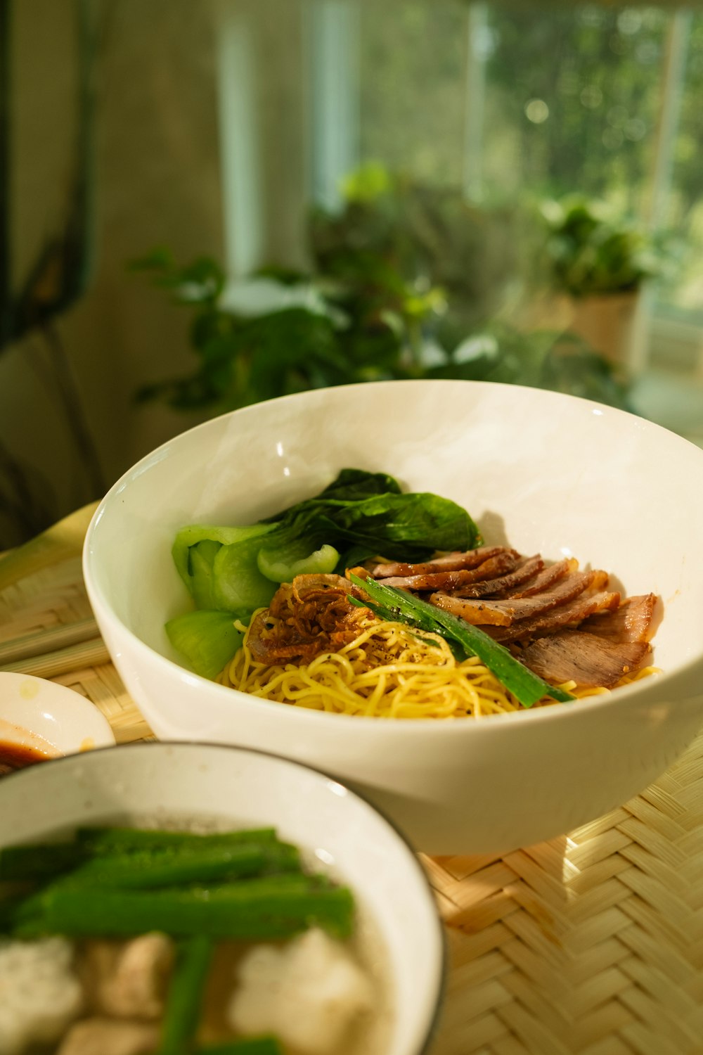 a white bowl filled with noodles and meat