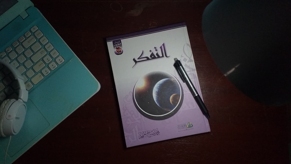 a book sitting on top of a desk next to a keyboard