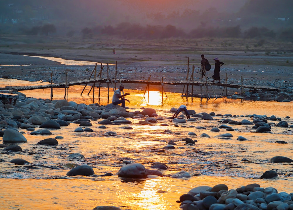 a group of people standing on a bridge over a river