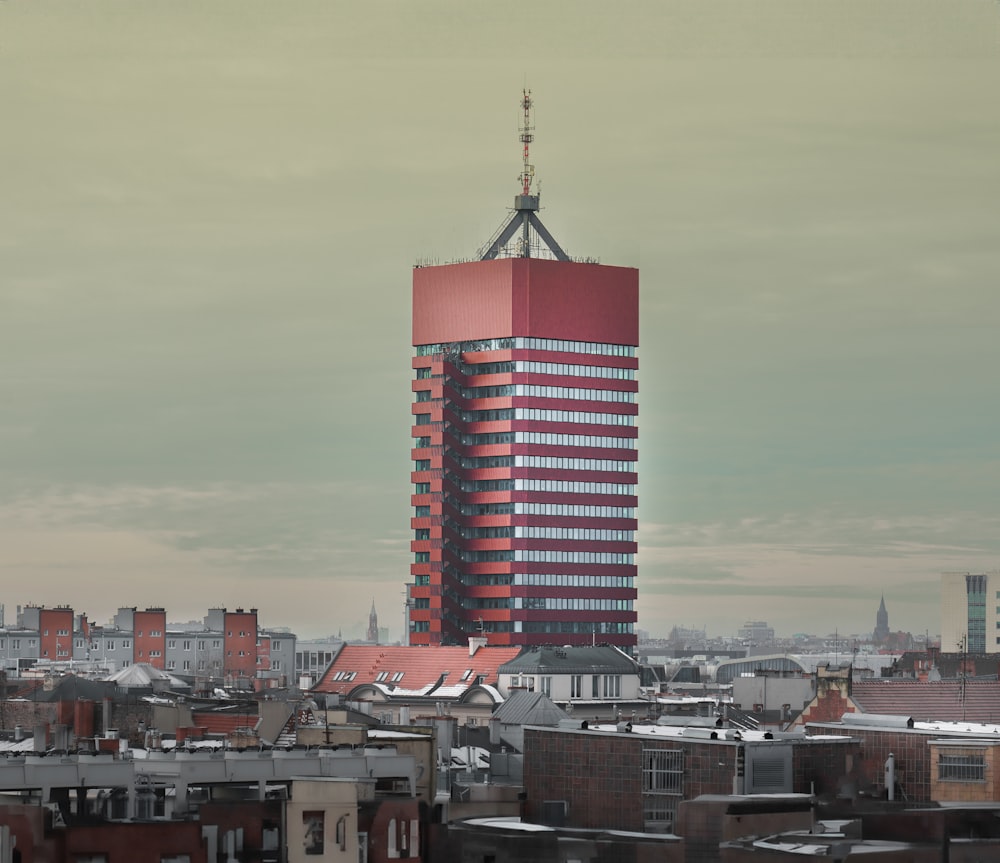 a tall red building with a sky scraper on top of it