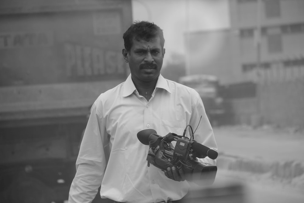 a black and white photo of a man holding a camera