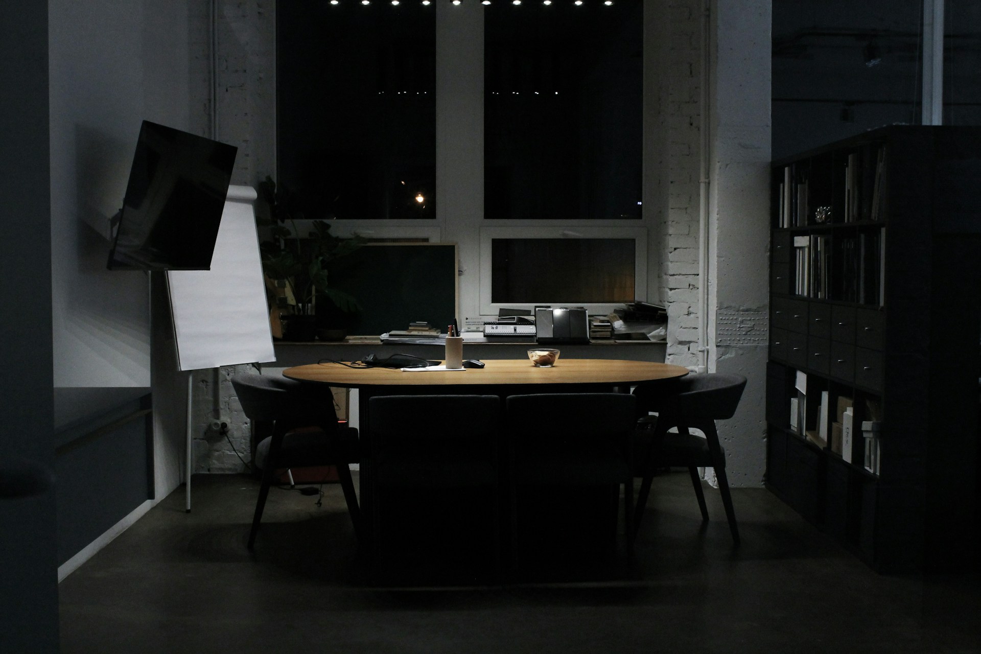 a dark room with a table and chairs