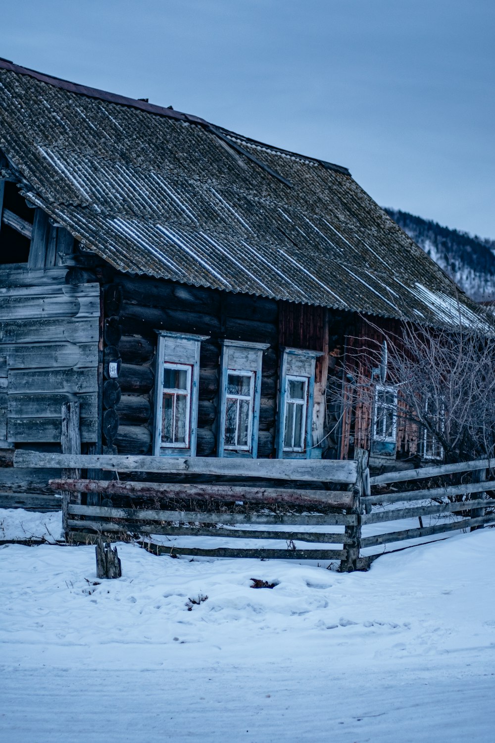 an old log cabin in the winter with snow on the ground