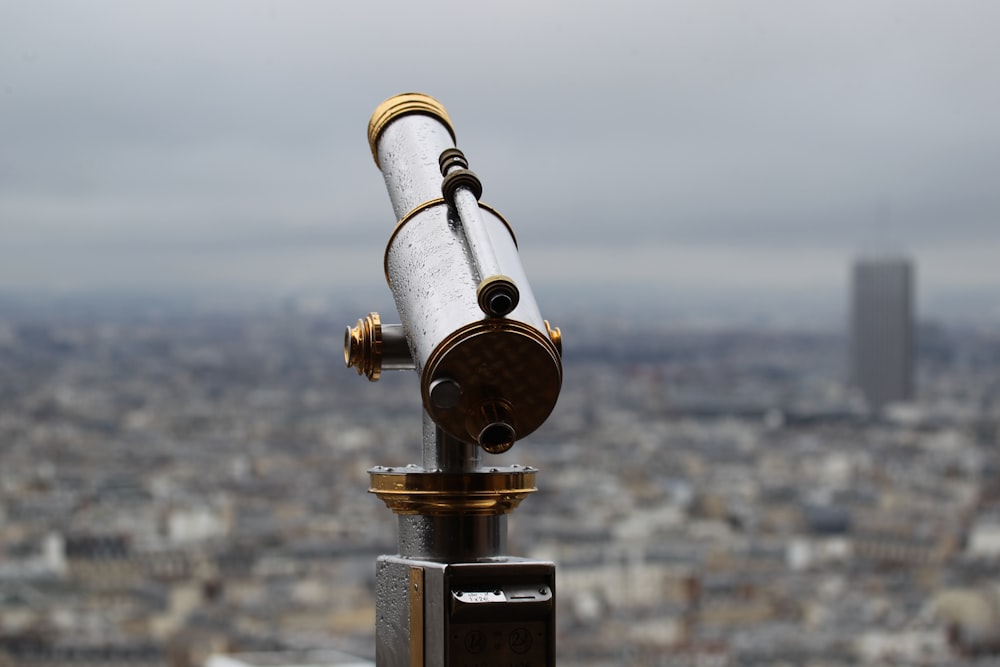 a telescope on top of a building with a city in the background