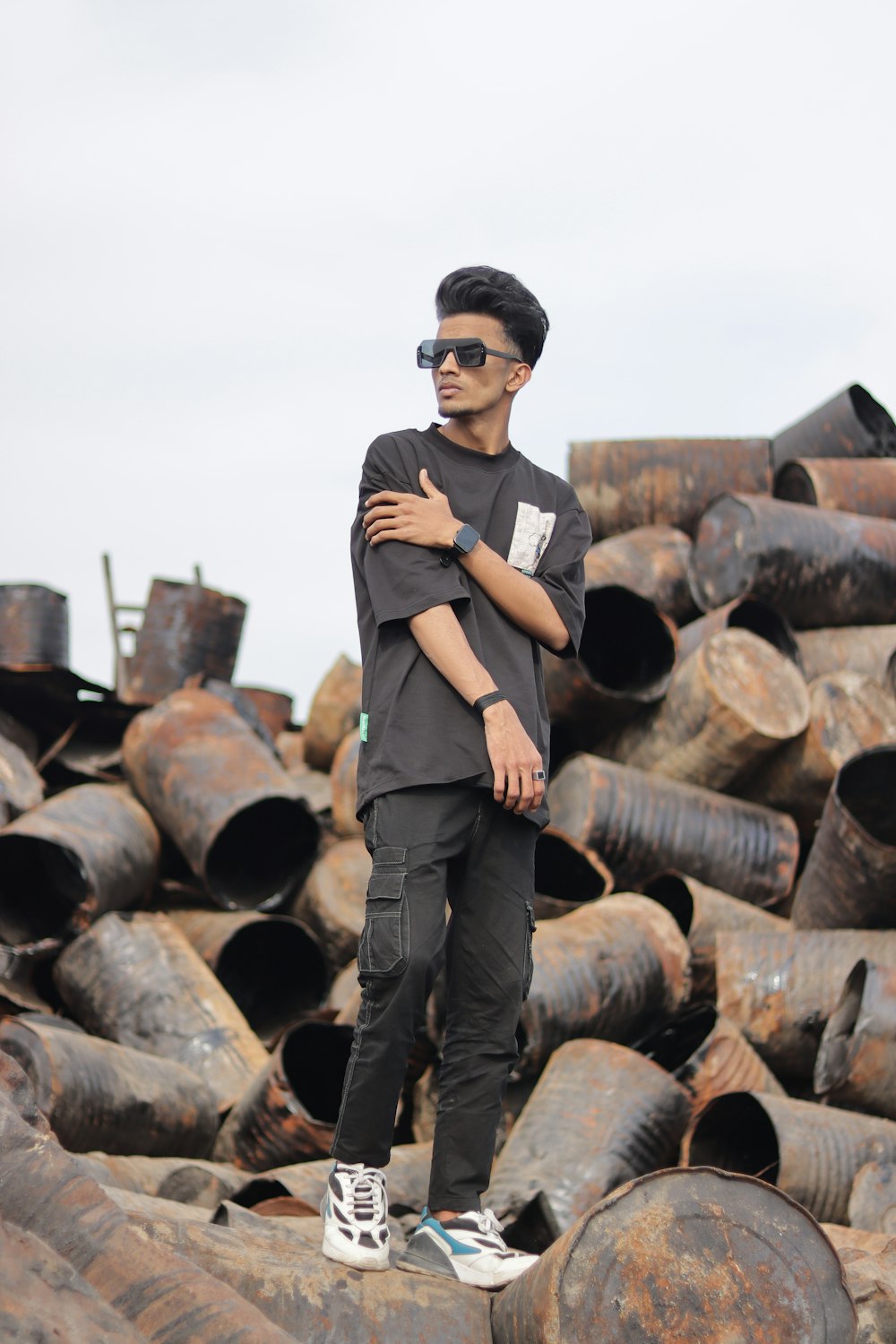 a man standing on top of a pile of metal pipes