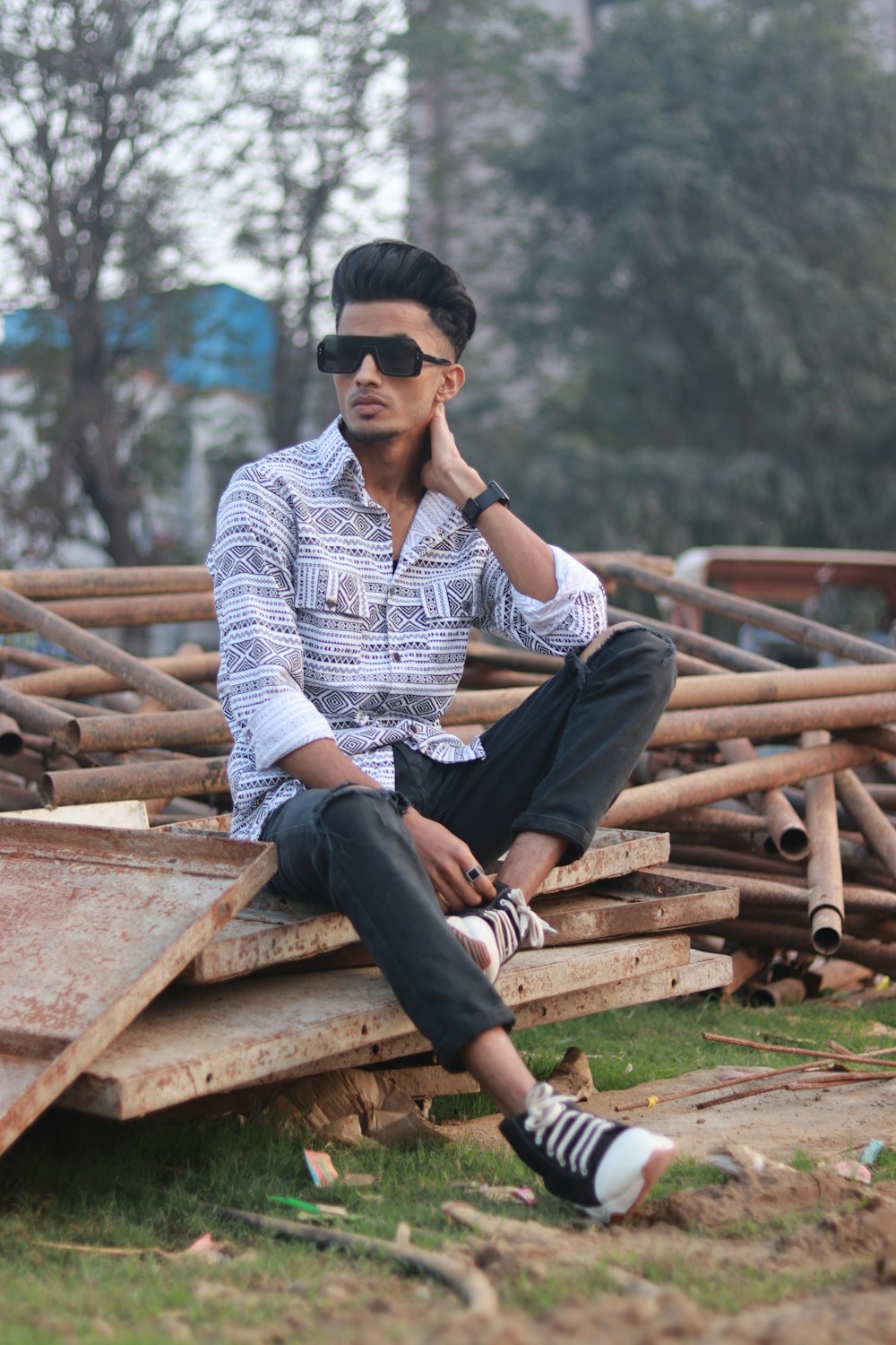 a man sitting on top of a pile of wood