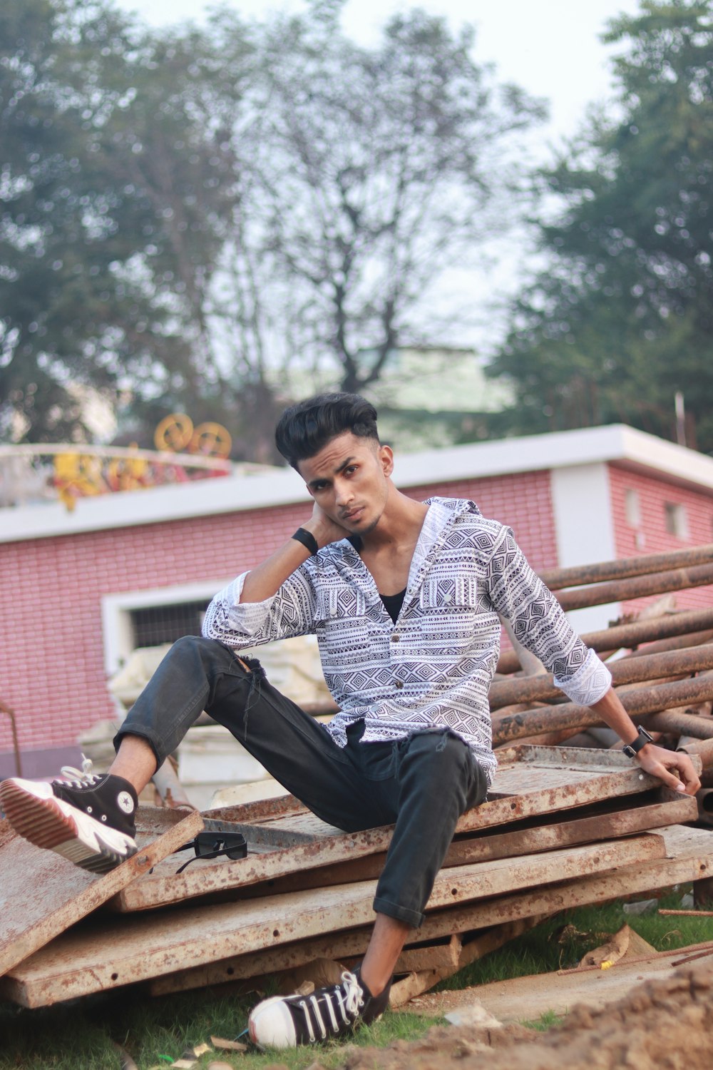 a man sitting on top of a pile of wood