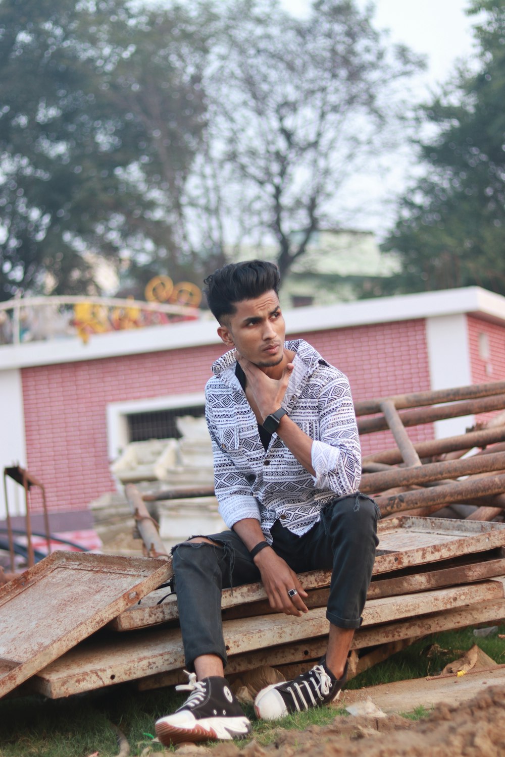 a man sitting on a pile of wooden pallets