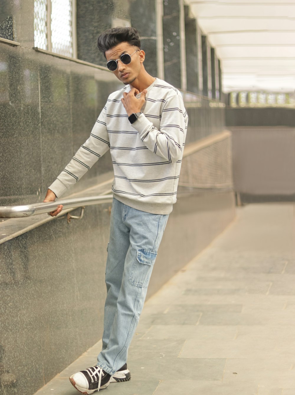 a man leaning against a wall with his hand on his chin