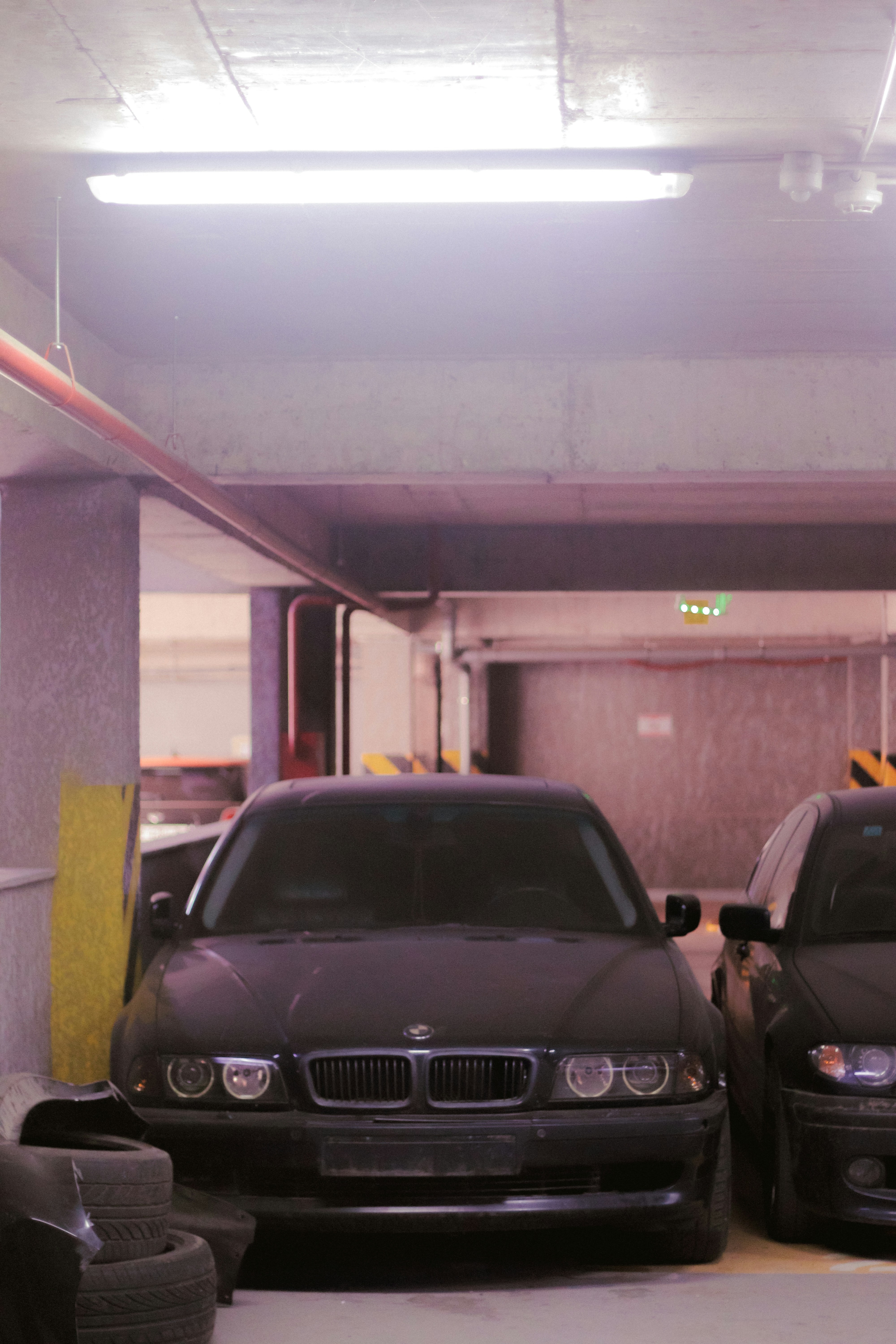 a parking garage with two cars parked in it