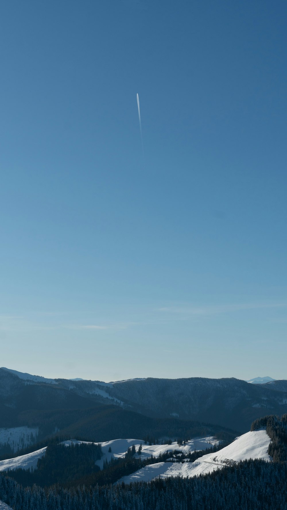 a clear blue sky over a snowy mountain range