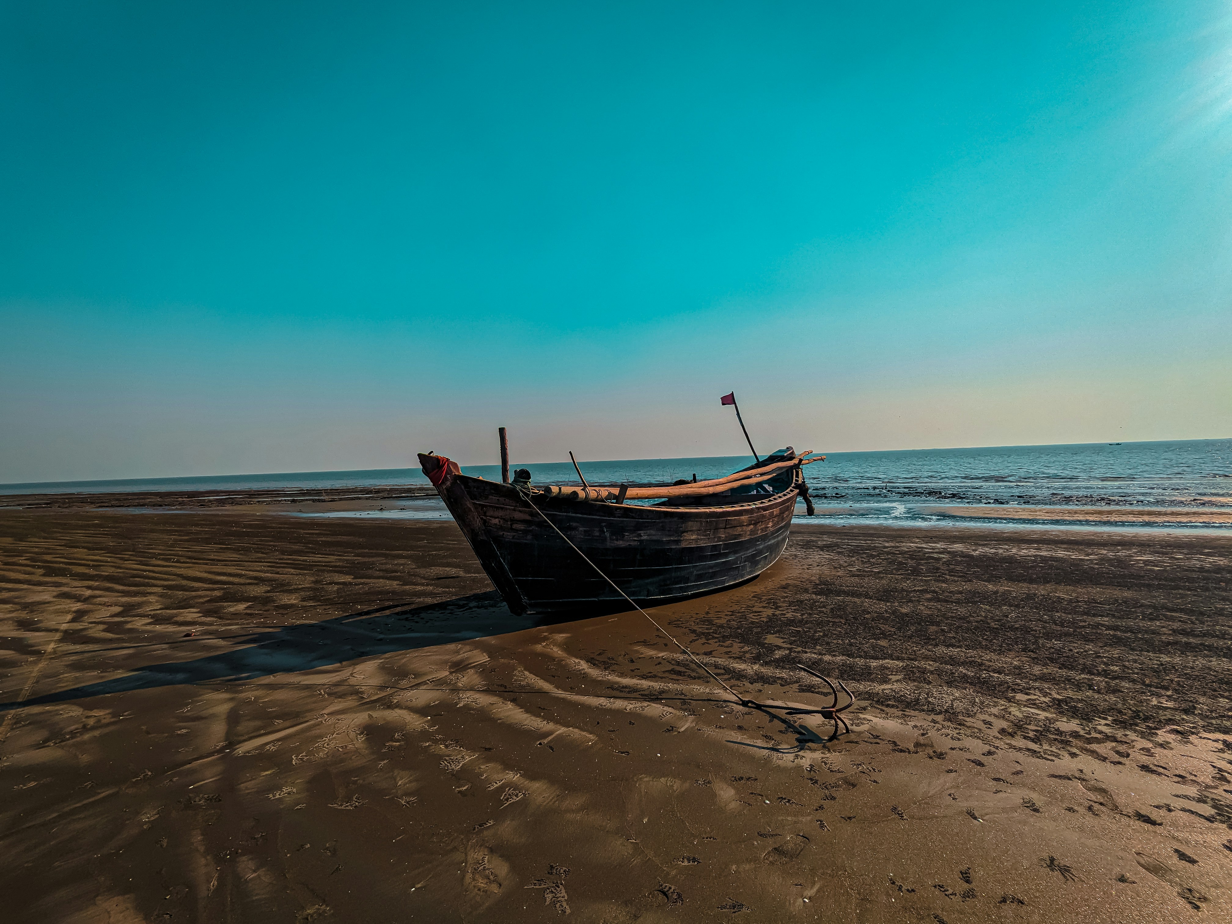 A boat sitting on top of a sandy beach photo – Free Blue Image on Unsplash