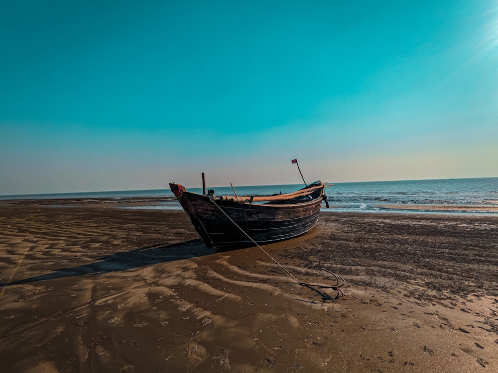 a boat sitting on top of a sandy beach