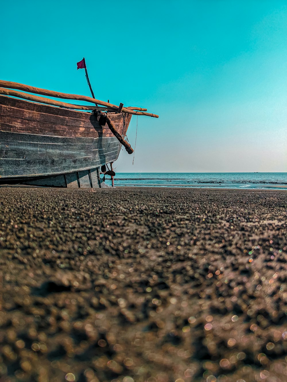 a boat sitting on top of a sandy beach