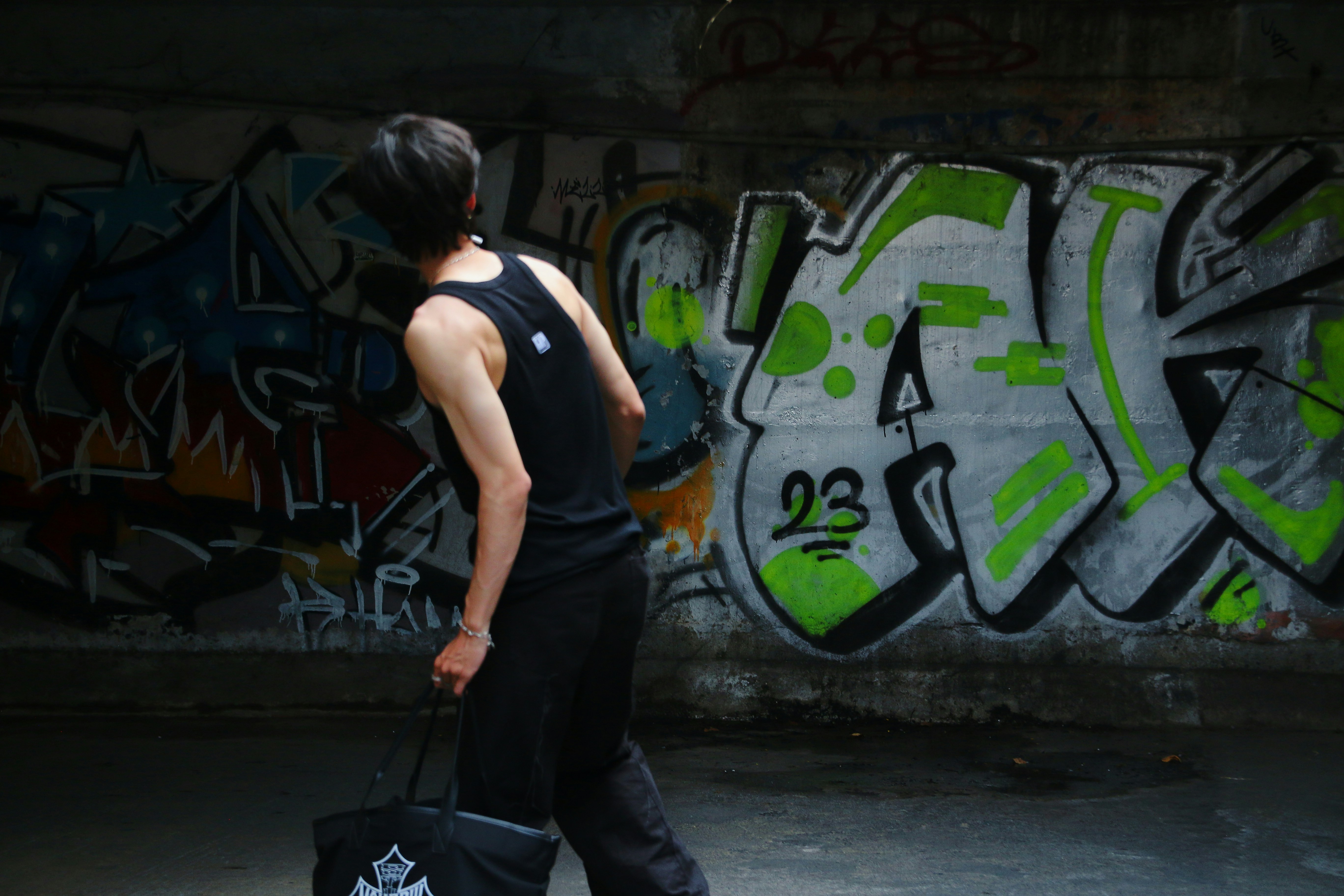 a man walking down a street carrying a black bag