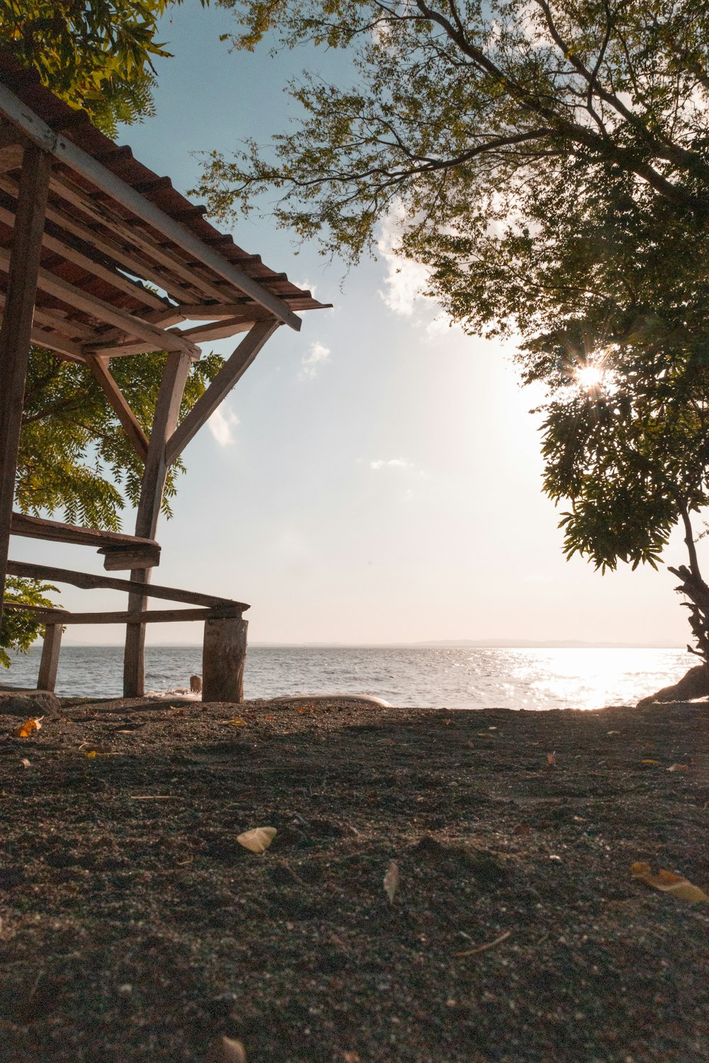 a wooden bench sitting on top of a sandy beach