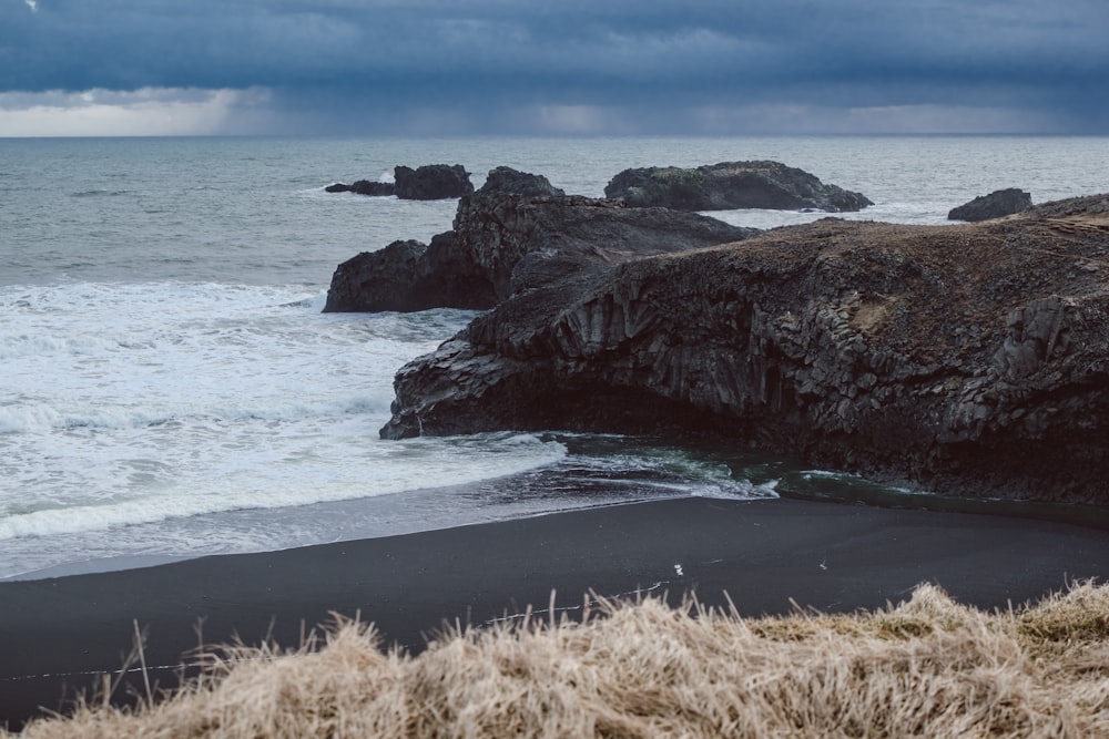 Une plage de sable noir sous un ciel nuageux