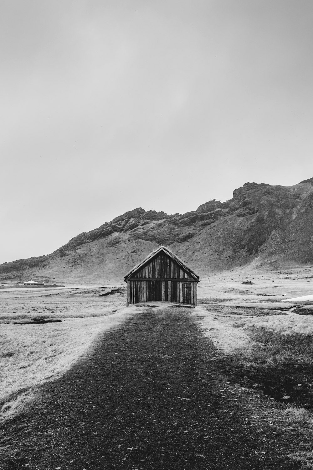 a black and white photo of a barn in the middle of nowhere