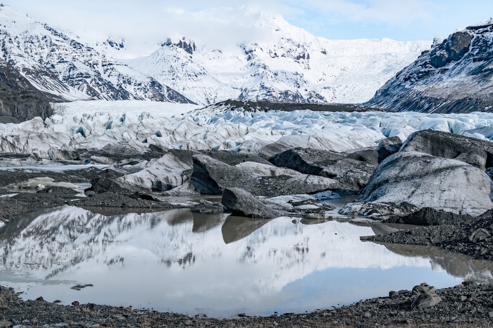 a glacier with snow covered mountains in the background