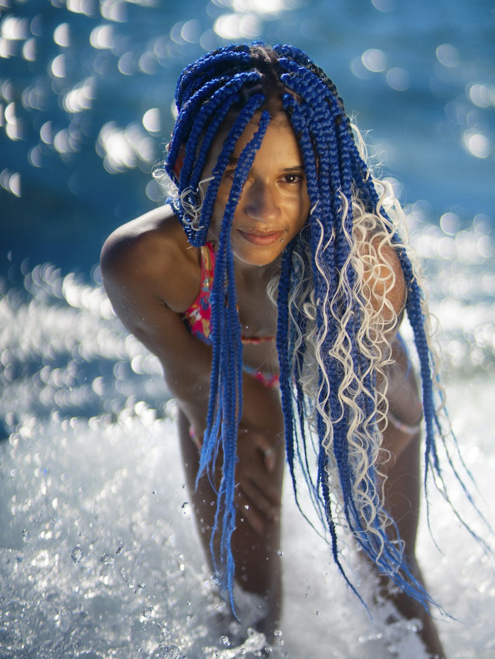 a young girl with blue dreadlocks in the ocean