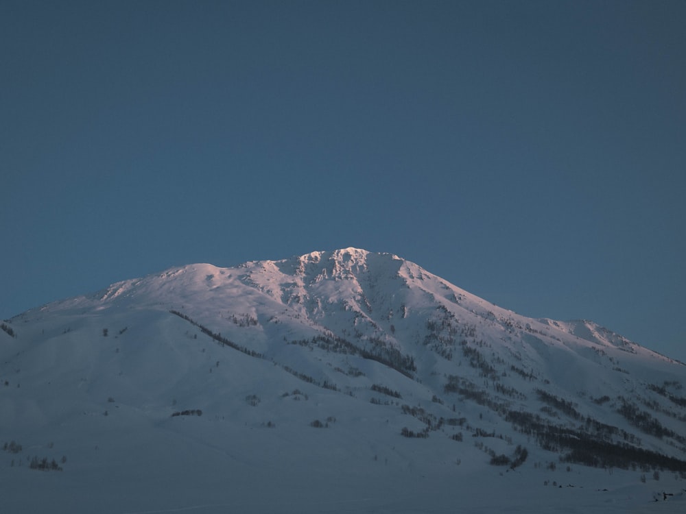 a mountain covered in snow under a blue sky