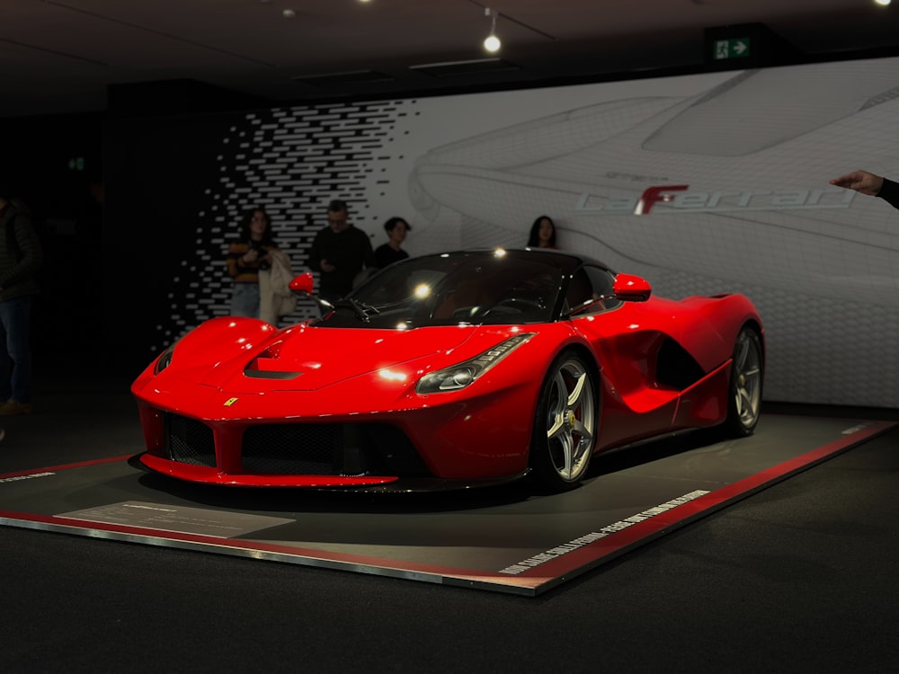 Une voiture de sport rouge exposée dans un salon de l’auto