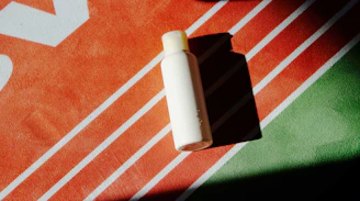 a bottle of lotion sitting on top of a towel