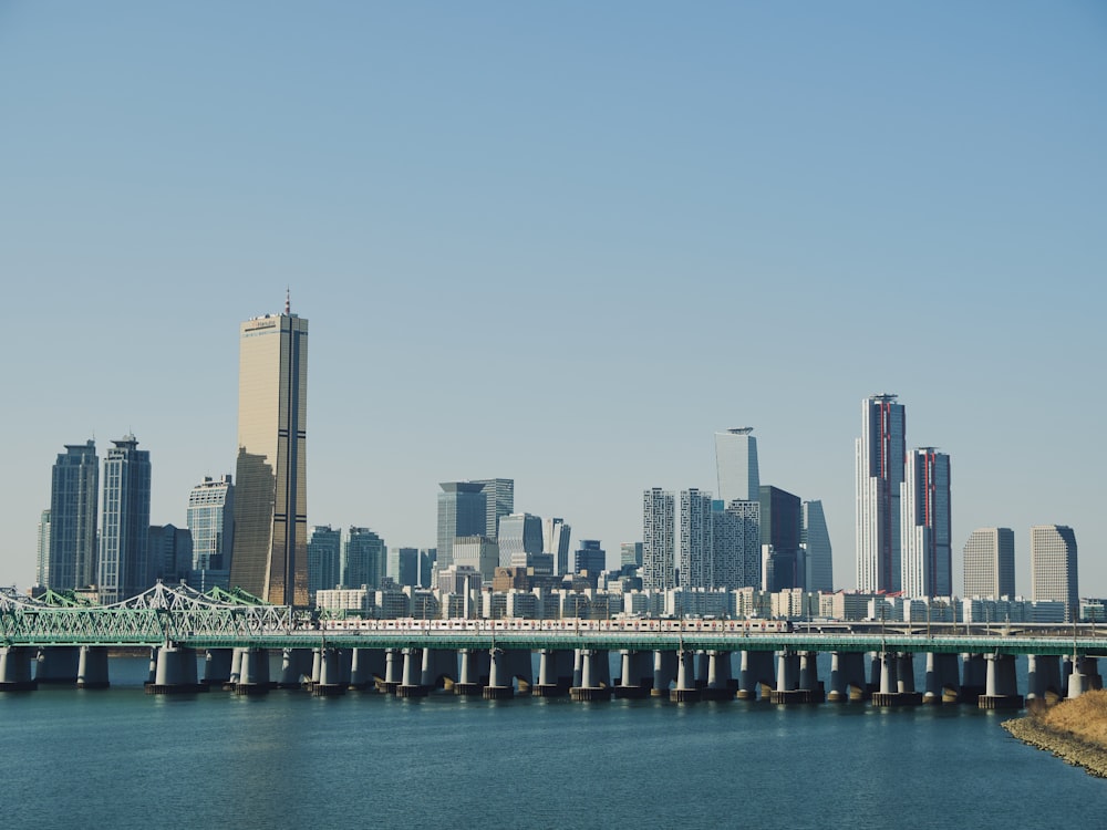 a bridge over a body of water with a city in the background