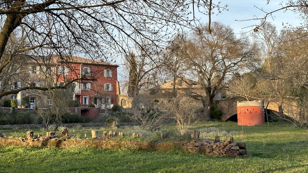 a red brick building sitting next to a lush green field