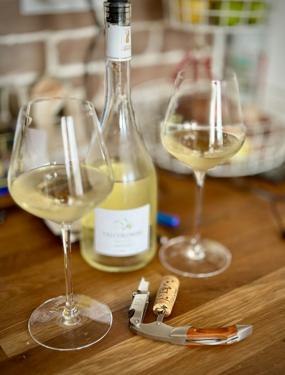 two wine glasses and a bottle of wine on a table