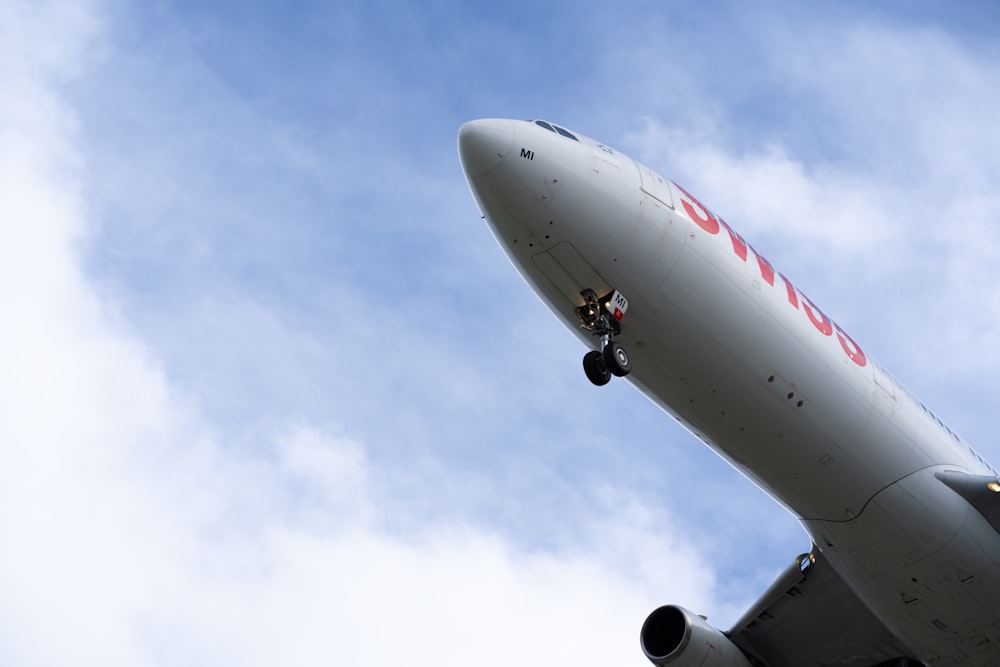 un grande aereo di linea che vola attraverso un cielo blu nuvoloso