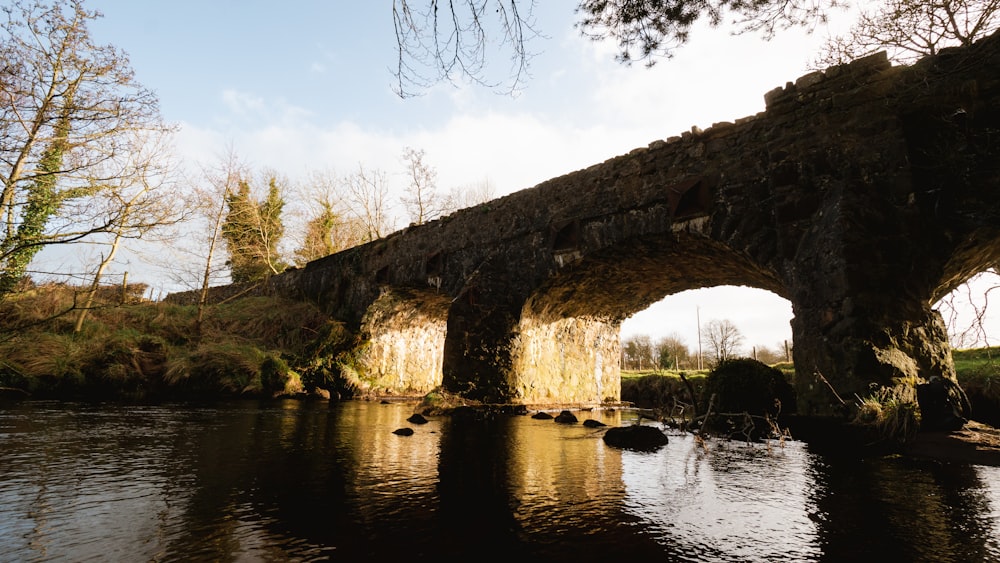 a stone bridge over a river with a sky background