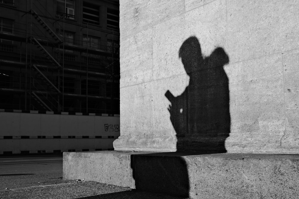 a shadow of a person holding a cell phone