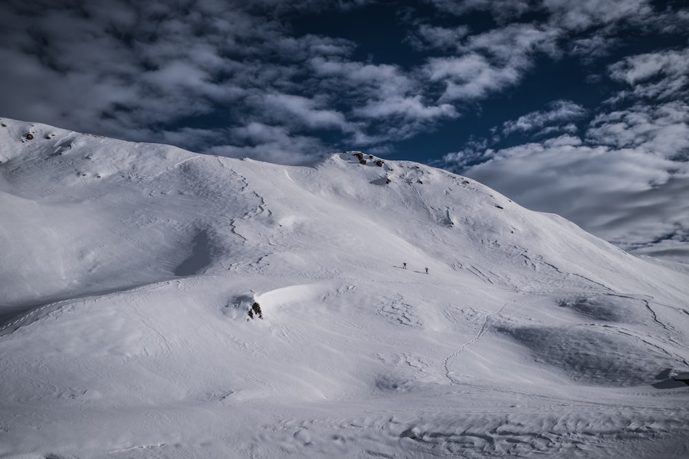 Ein Mann fährt mit Skiern die Seite einer schneebedeckten Piste hinunter