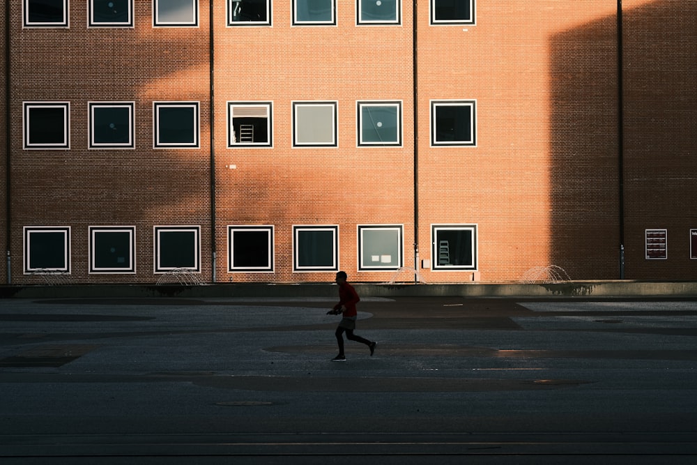 한 사람이 건물 앞에서 달리고 있다