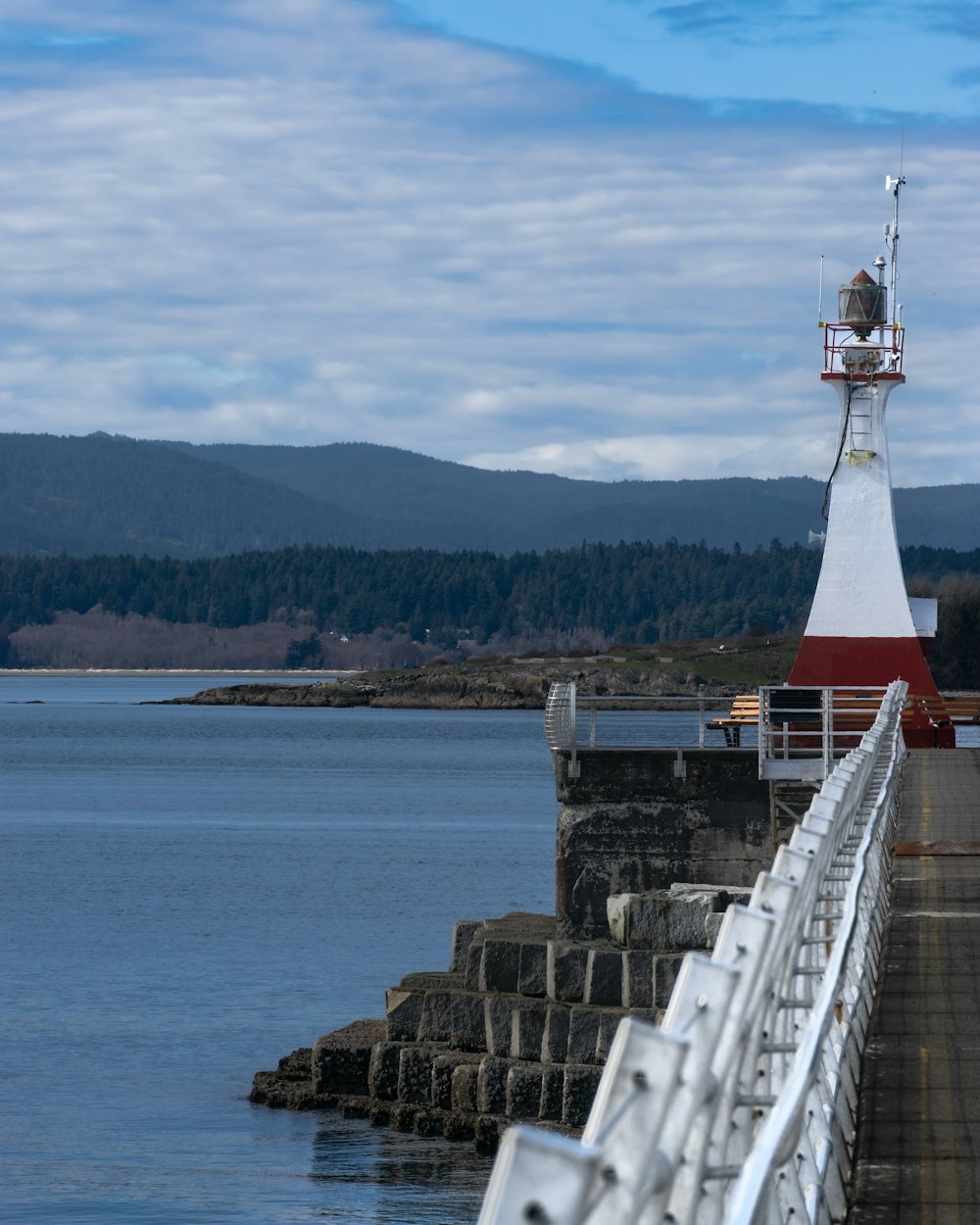 a lighthouse sitting on top of a pier next to a body of water