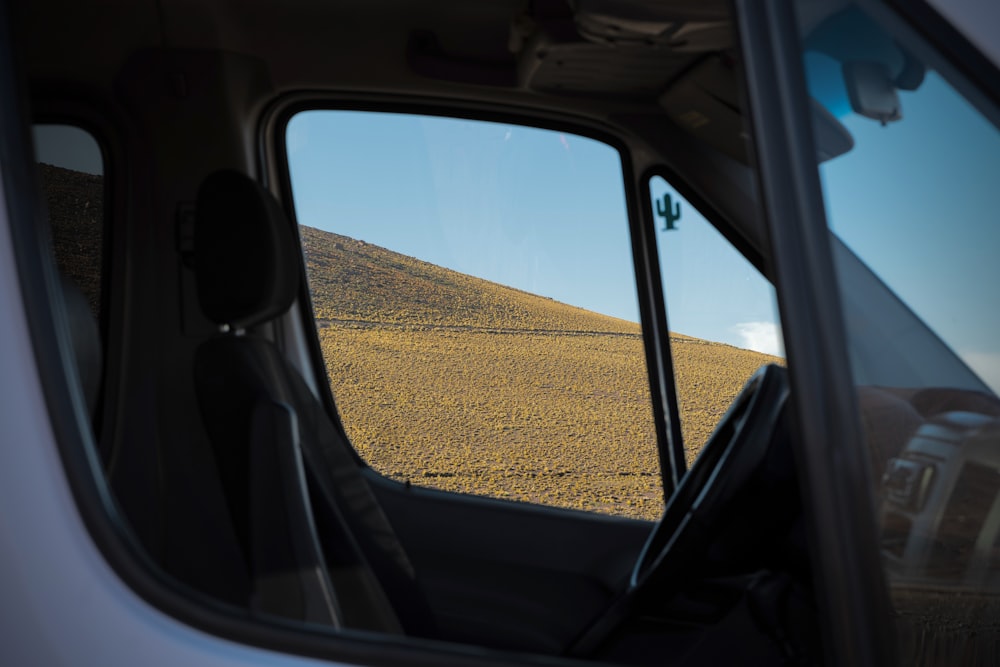 a view of a hill from inside a car