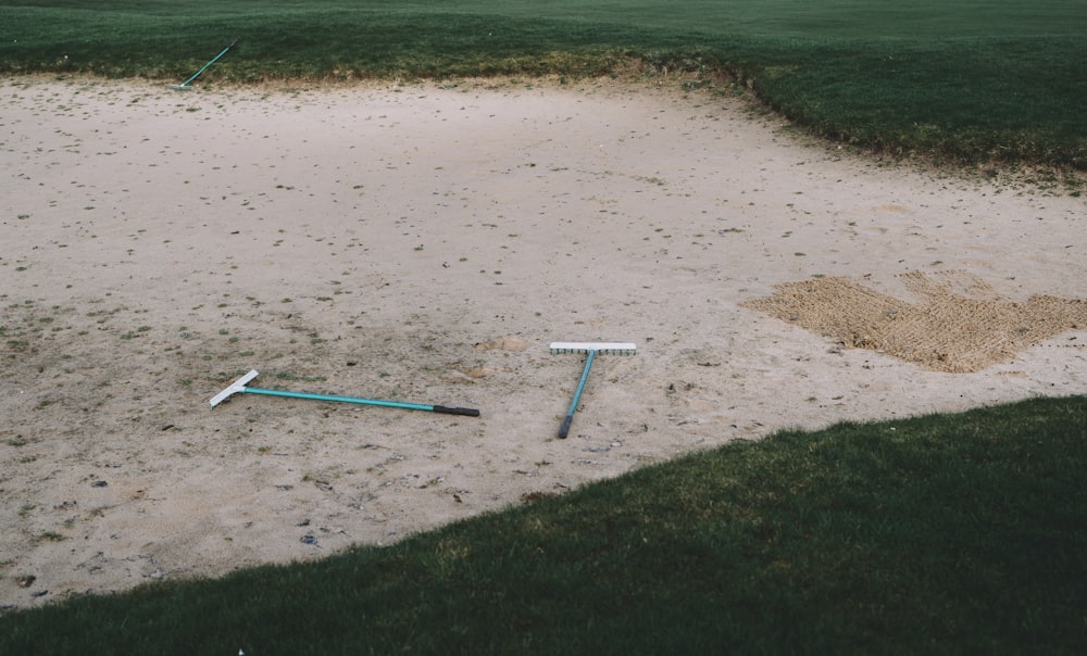 a broken baseball bat laying in the sand