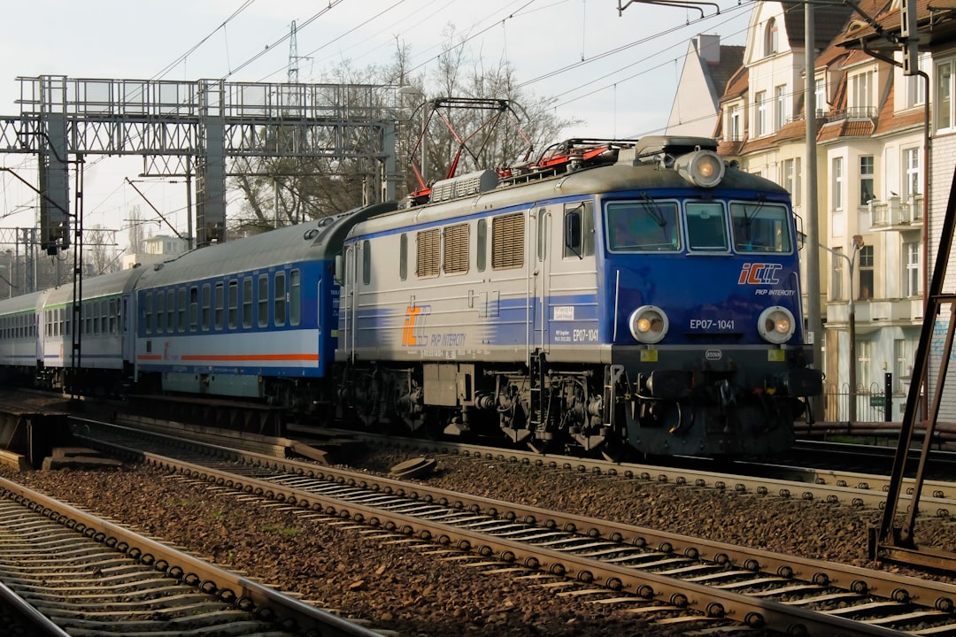 a blue and white train traveling down train tracks,