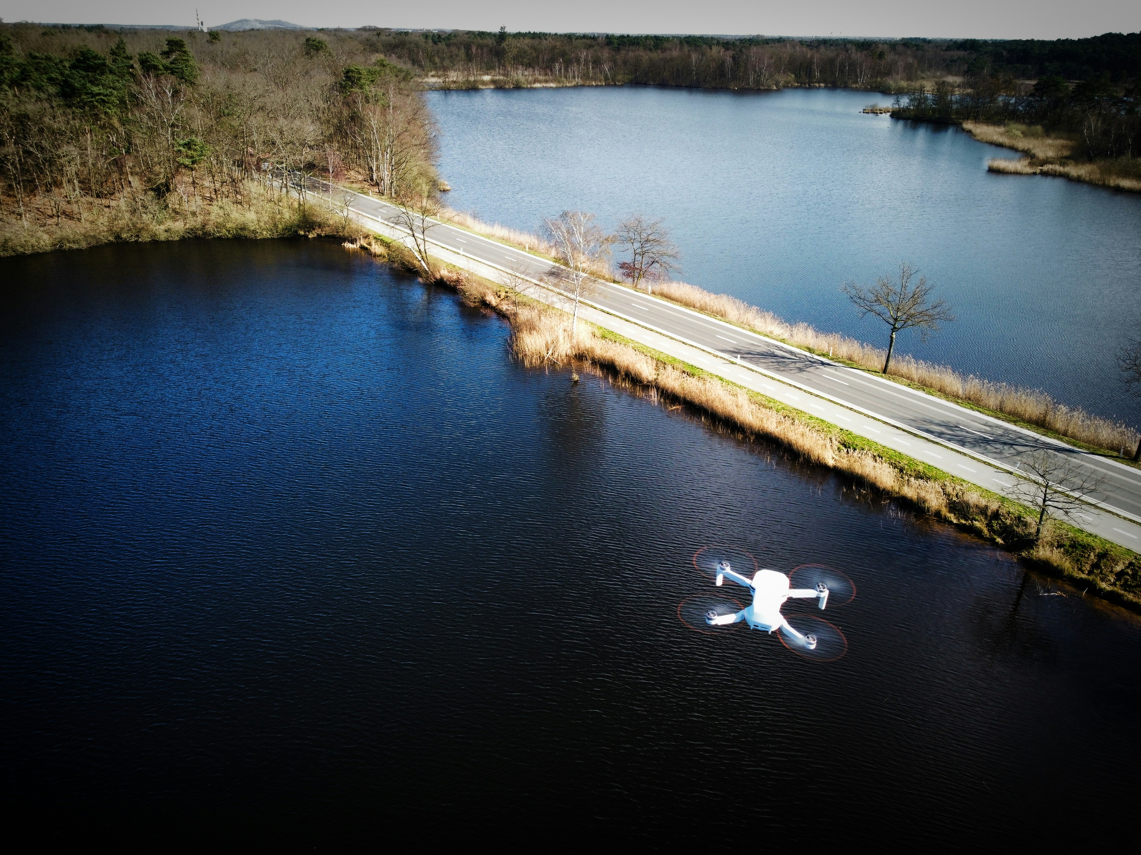 an aerial view of a road and a lake