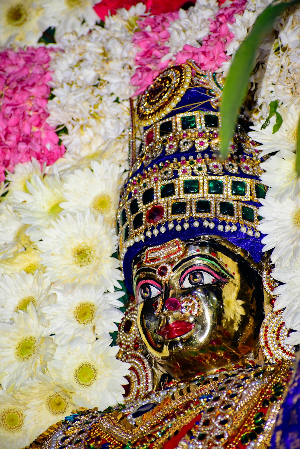 a close up of a statue of a person surrounded by flowers