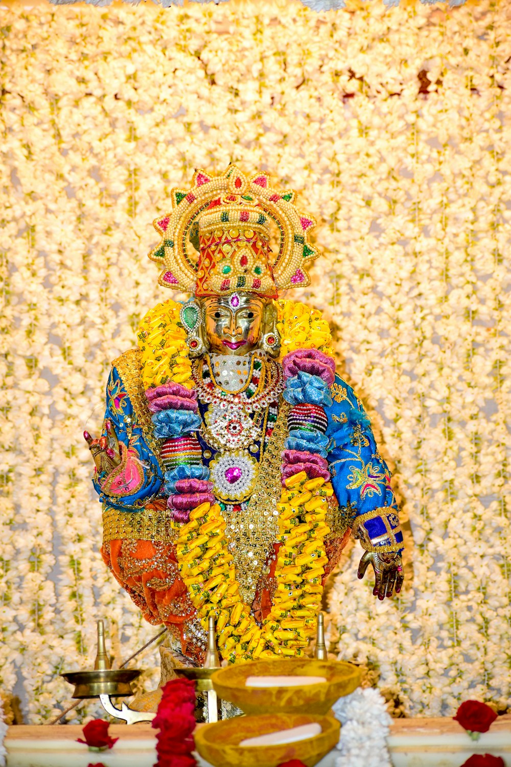 a statue of a hindu god in front of a backdrop