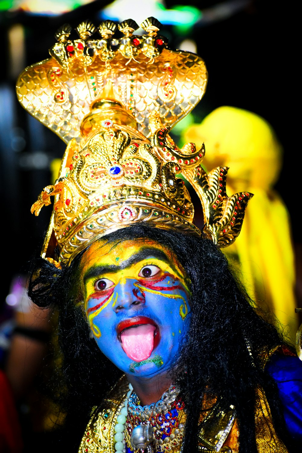 a man with a painted face and a golden crown on his head
