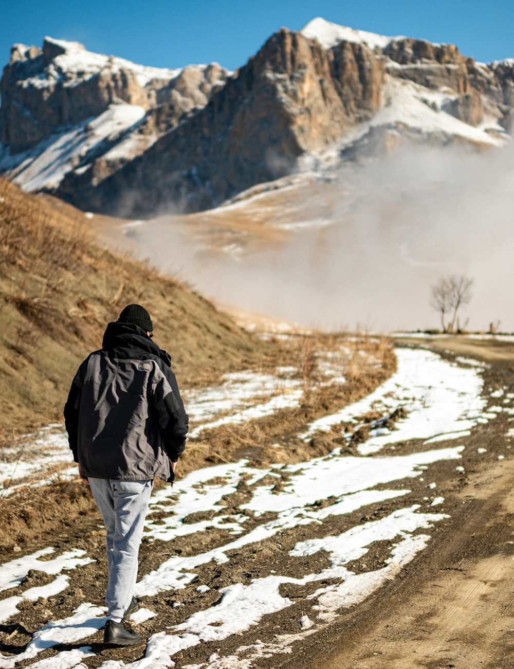 a man walking down a snow covered road