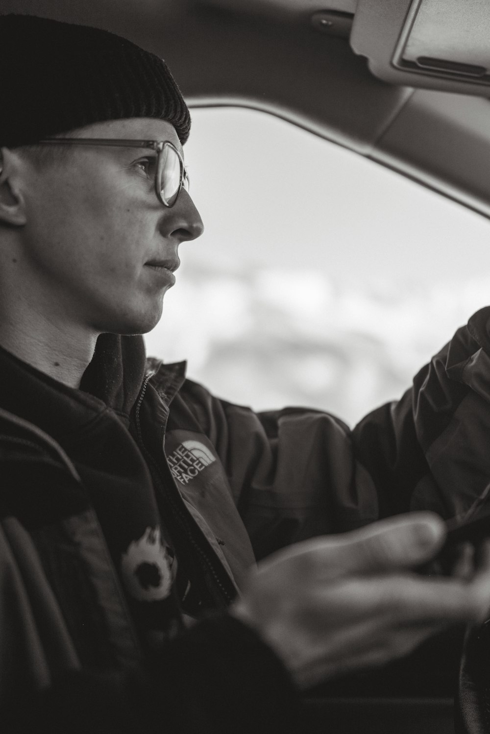 a man sitting in a car holding a cell phone