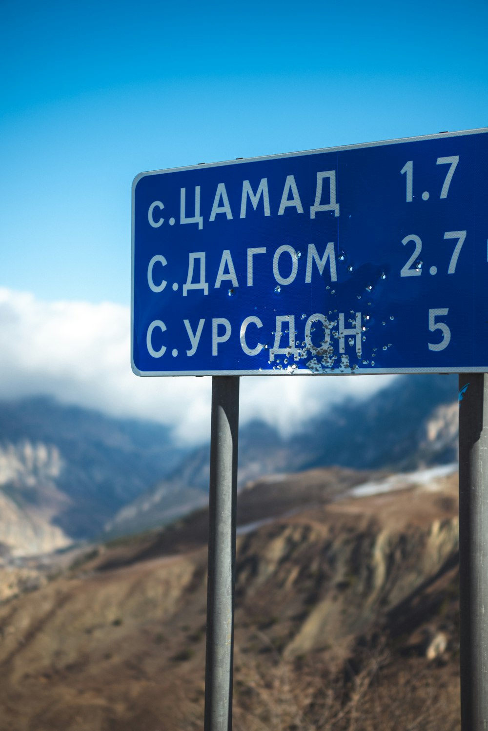 a blue street sign sitting on the side of a road