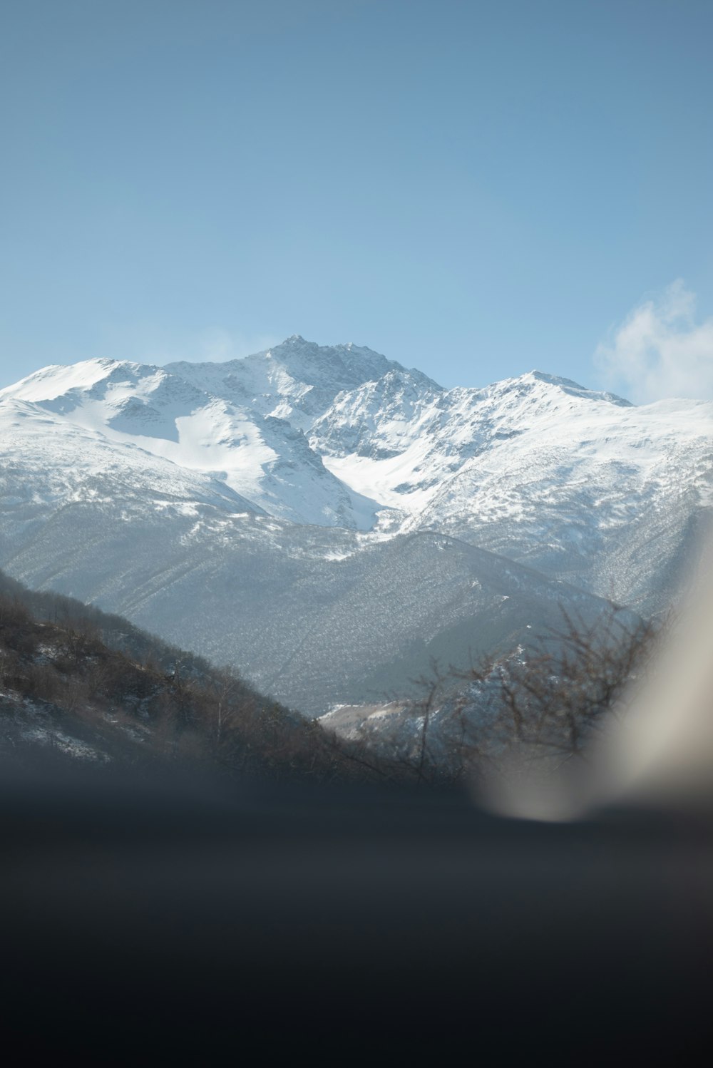 a view of a snow covered mountain from a vehicle